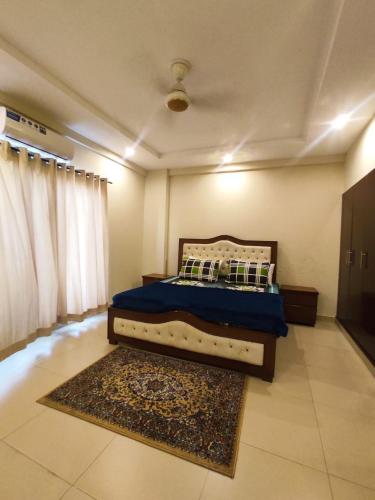 1 dormitorio con 1 cama con edredón azul y alfombra en One bedroom Apartment - Cube Apartment, en Islamabad
