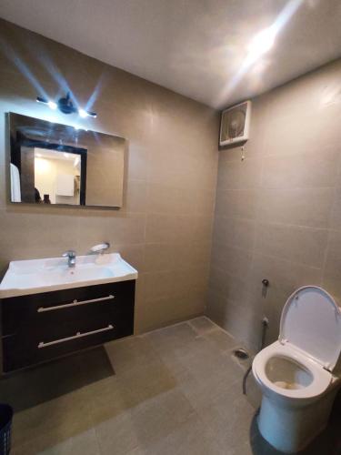 Un baño con inodoro, lavabo y espejo. en One bedroom Apartment - Cube Apartment, en Islamabad