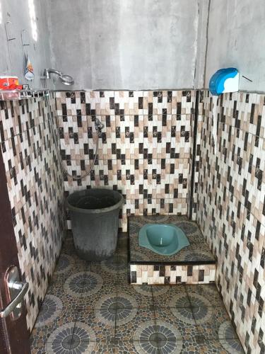 a bathroom with a toilet in a tiled floor at Komodo Wisata Homestay in Komodo
