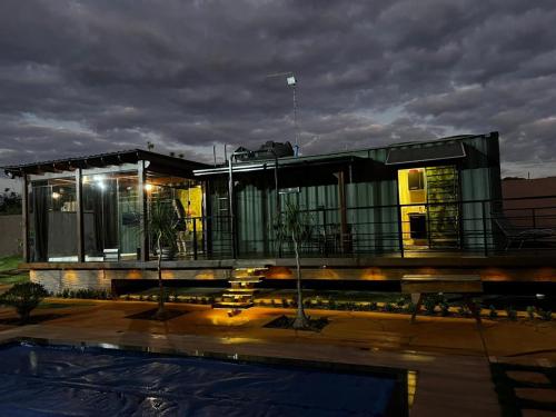 una casa con piscina delante de ella en Casa Container, en Santa Rita do Passa Quatro