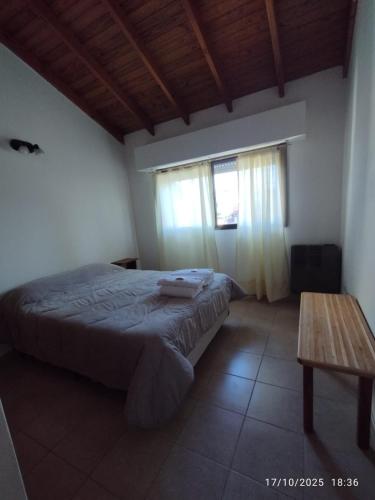 玛德琳港Casa Paso的一间卧室，配有一张床和一张木桌