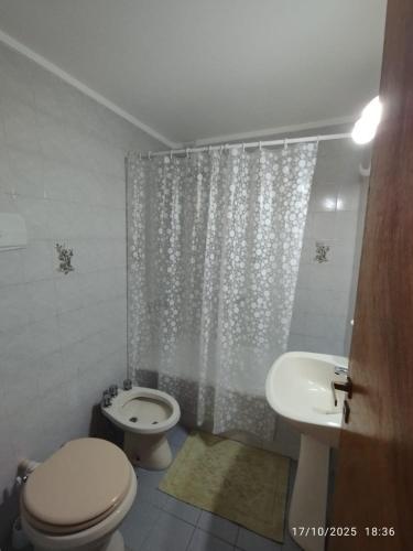 a bathroom with a toilet and a sink and a shower at Casa Paso in Puerto Madryn