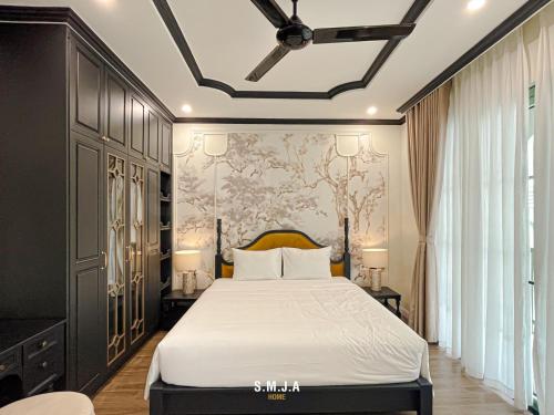 ein Schlafzimmer mit einem Bett und einer Wand mit einem Gemälde in der Unterkunft Villa Vanda Phu Quoc in Phu Quoc