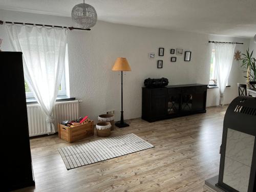 ein Wohnzimmer mit Holzboden und einer Lampe in der Unterkunft Zum alten Rittergut in Malschwitz