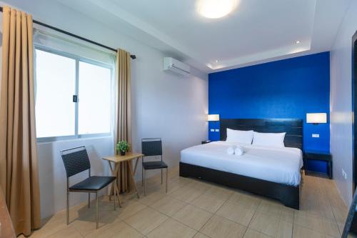 a bedroom with a bed and a blue wall at The Strype Hotel Tagaytay in Tagaytay
