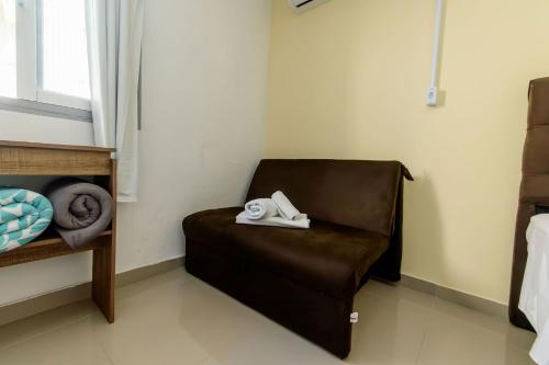 a leather chair with a pair of shoes sitting on it at Casa Aconchegante no Centro BC AV2393 in Balneário Camboriú