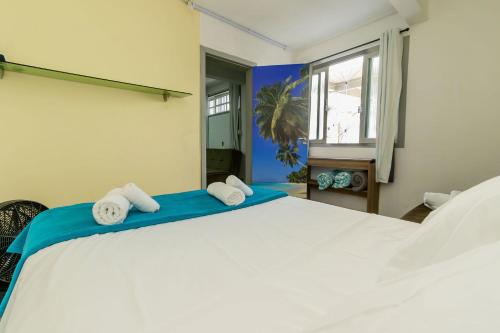 a bedroom with a large white bed with towels on it at Casa Aconchegante no Centro BC AV2393 in Balneário Camboriú