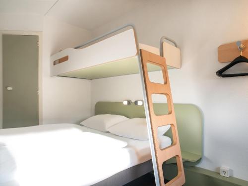 a bedroom with a bunk bed and a mirror at B&B Hotel Lübeck Berliner-Platz in Lübeck