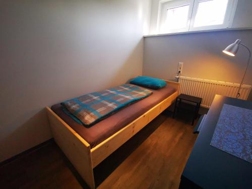 a small bedroom with a wooden bed and a window at Einzelzimmer mit Bad HG 3 in Zwickau