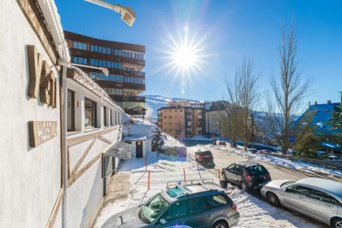una calle cubierta de nieve con coches aparcados en el lateral de un edificio en Hostal Yeti, en Sierra Nevada