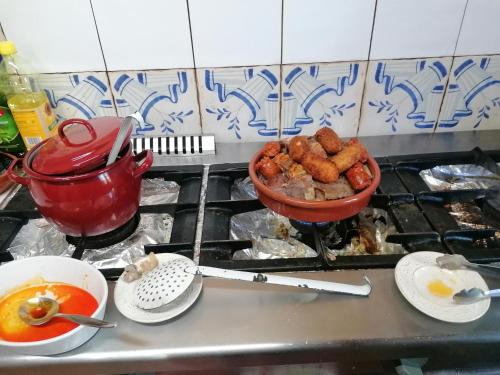 a stove top with a pot of food and a bowl of food at Hostería Casa Flor in Murias de Rechivaldo