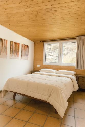 a bedroom with a large bed with two windows at Hostal Yeti in Sierra Nevada