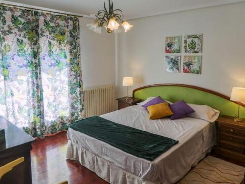 Schlafzimmer mit einem Bett mit einem grünen Kopfteil in der Unterkunft Casa Relajante Aljezar in Teruel