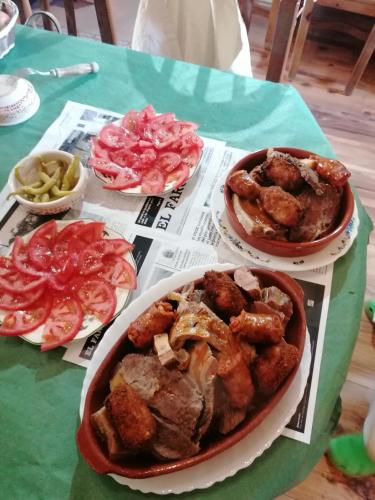 a table with three plates of food on it at Hostería Casa Flor in Murias de Rechivaldo