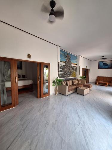 ein großes Wohnzimmer mit einem Sofa und einem Bett in der Unterkunft Tenang Villas - With Private Pool in Nusa Ceningan