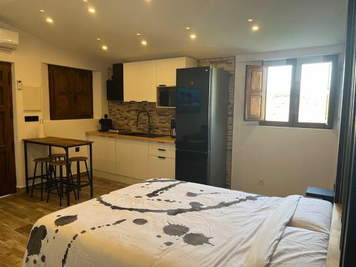 a kitchen with a bed and a refrigerator and a table at Escapada rural con sauna y relax en la naturaleza in Níjar