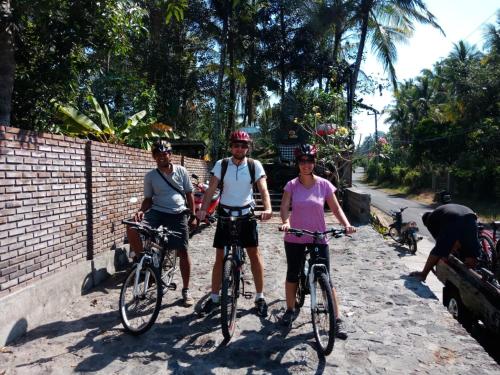 a group of people riding bikes down a street at Alas Arum Ecolodge in Tabanan