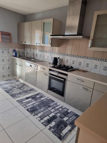 una cocina con gabinetes blancos y un horno con placa de cocina en Maison Gardelle, en Thiers