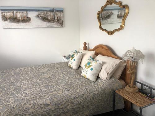 een slaapkamer met een bed met kussens en een spiegel bij Num 29 in Newquay
