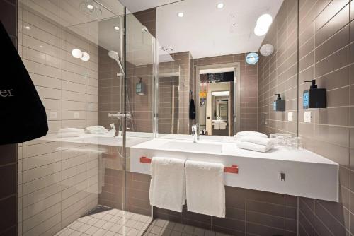 a bathroom with a sink and a large mirror at Comfort Hotel Bergen Airport in Bergen