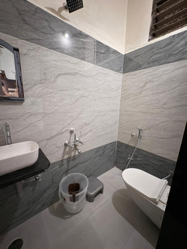 a bathroom with a sink and a toilet at Hotel chaitanya in Maheshwar