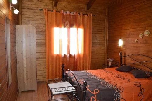 a bedroom with an orange bed and a window at Casas de Montanha da Gralheira in Gralheira