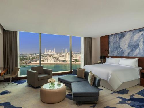 a hotel room with a bed and a large window at Fairmont Bab Al Bahr in Abu Dhabi