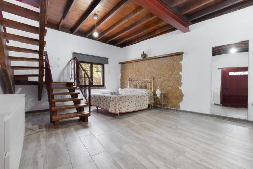 a bedroom with a bed and a staircase in a room at Villa Alma in Vega de San Mateo