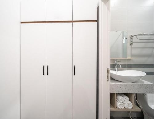 a bathroom with white cabinets and a sink at UYÊN GIA HOTEL-PHÚ QUỐC in Phu Quoc