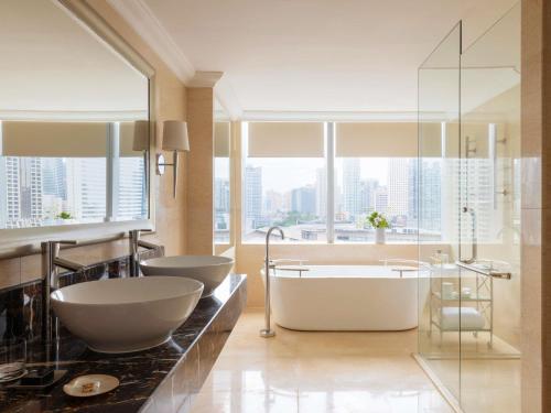 a bathroom with two sinks and a bath tub at Raffles Makati in Manila