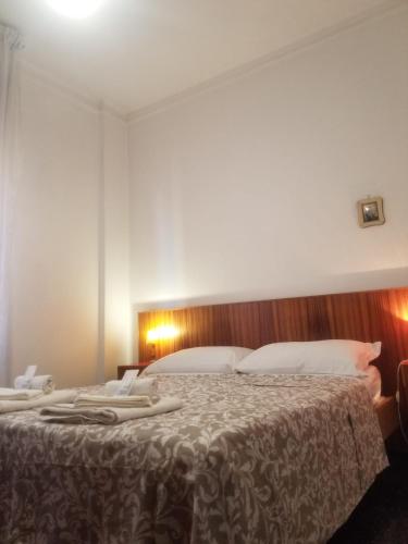 een slaapkamer met een groot bed met witte kussens bij Casa Carrara in Genua