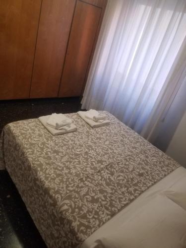 een bed met twee handdoeken erop bij Casa Carrara in Genua