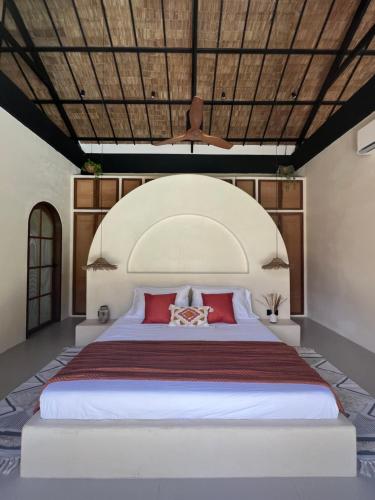ein Schlafzimmer mit einem großen weißen Bett mit roten Kissen in der Unterkunft Alma Villas in Paliton