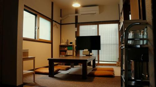 東京にある亀のやのテーブルとテレビのあるリビングルーム