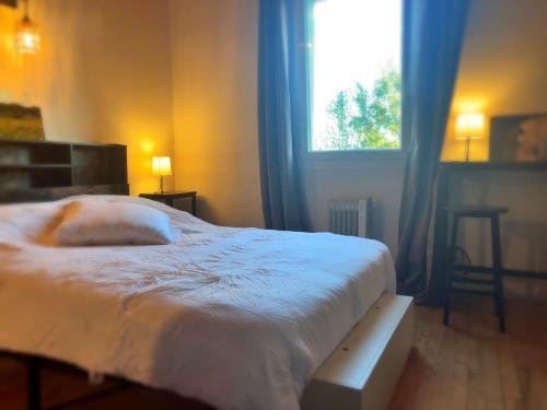 a bedroom with a white bed and a window at Chez Benoit, séjour Zen, chambre d'amis in Mazerolles