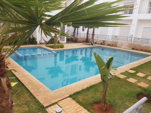 エル・ハーフラにあるSables d'or flat apartementのヤシの木が隣接する大型スイミングプール