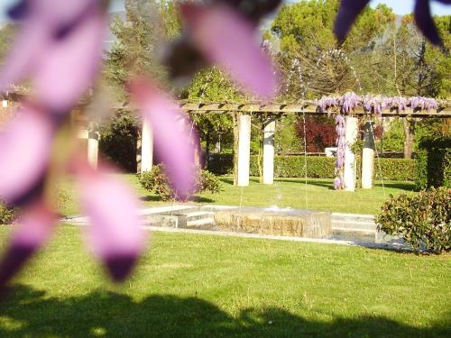 a garden with a fountain and a pergola at Hotel Villaguarda Prosecco Area in Follina
