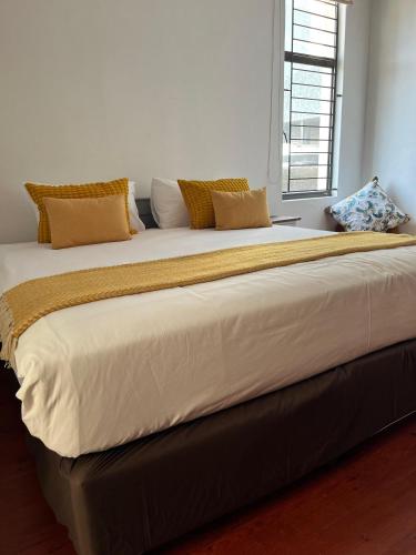 a large bed in a room with a window at Musgrave Escape in Durban
