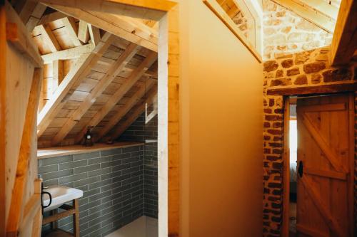 a bathroom with a vaulted ceiling and a wooden door at La Petite Maison dans la Prairie in Pepinster