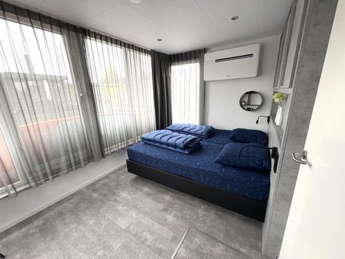 a bedroom with a bed with blue pillows in it at De Maasterp - Watervillage 21 in Ohé en Laak