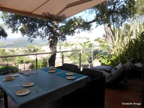 a blue table on a balcony with a view at Au Jardin Des Couleurs in Pierrefeu-du-Var