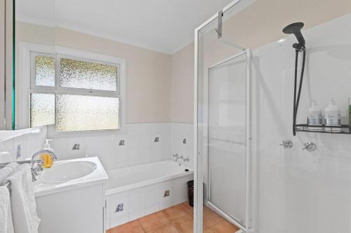 a white bathroom with a sink and a shower at Charming home on Percy in Devonport