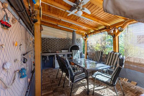 patio con mesa y sillas y ventilador de techo en Apartment Kreslin, en Vantačići