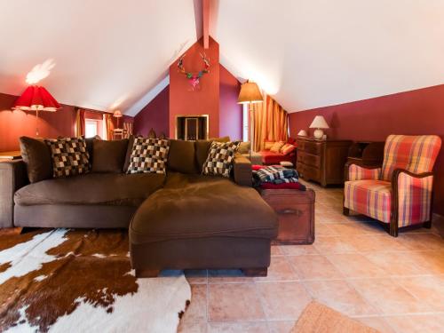 a living room with a brown couch and a chair at Luxury Pool Villa in Sosoye in Sosoye