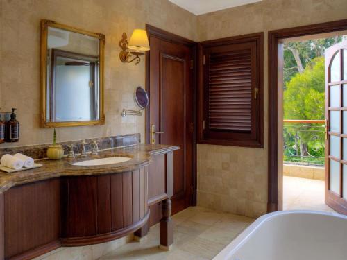 a bathroom with a tub and a sink and a mirror at Fairmont Mount Kenya Safari Club in Nanyuki