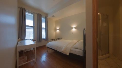 a bedroom with a bed and two windows at U.S. Pacific Hotel in New York