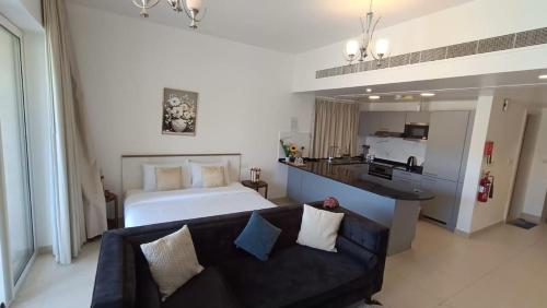 Cet appartement comprend une chambre avec un lit et un canapé ainsi qu'une cuisine. dans l'établissement Deluxe As sifah resort suites, jebel sifah resort, à As Sīfah