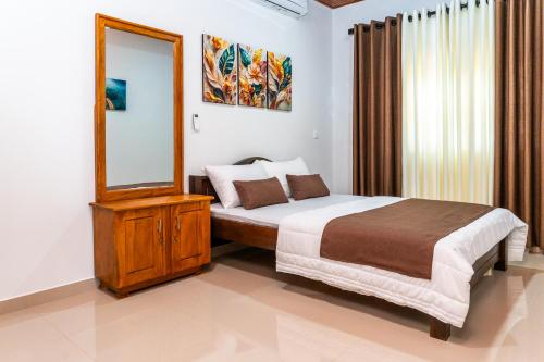 Un dormitorio con una cama grande y un espejo. en Villa Tuskaara, en Tangalle