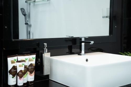 Un baño con un lavabo blanco y un espejo. en Villa Tuskaara, en Tangalle