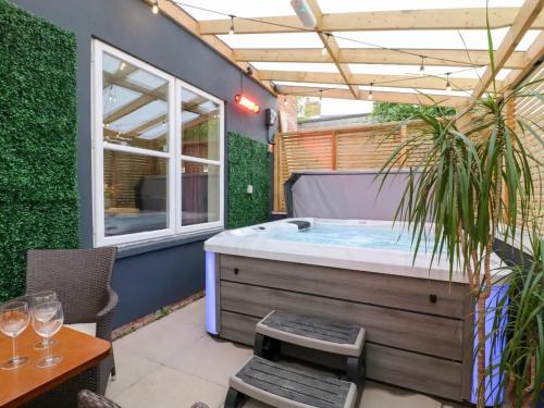 a jacuzzi tub in a patio with a table at Hambleton House Castle Donington in Castle Donington